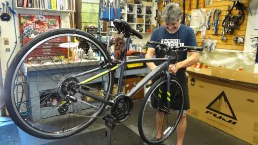 A Renaissance Cyclery technician working on a customer's bicycle at the counter