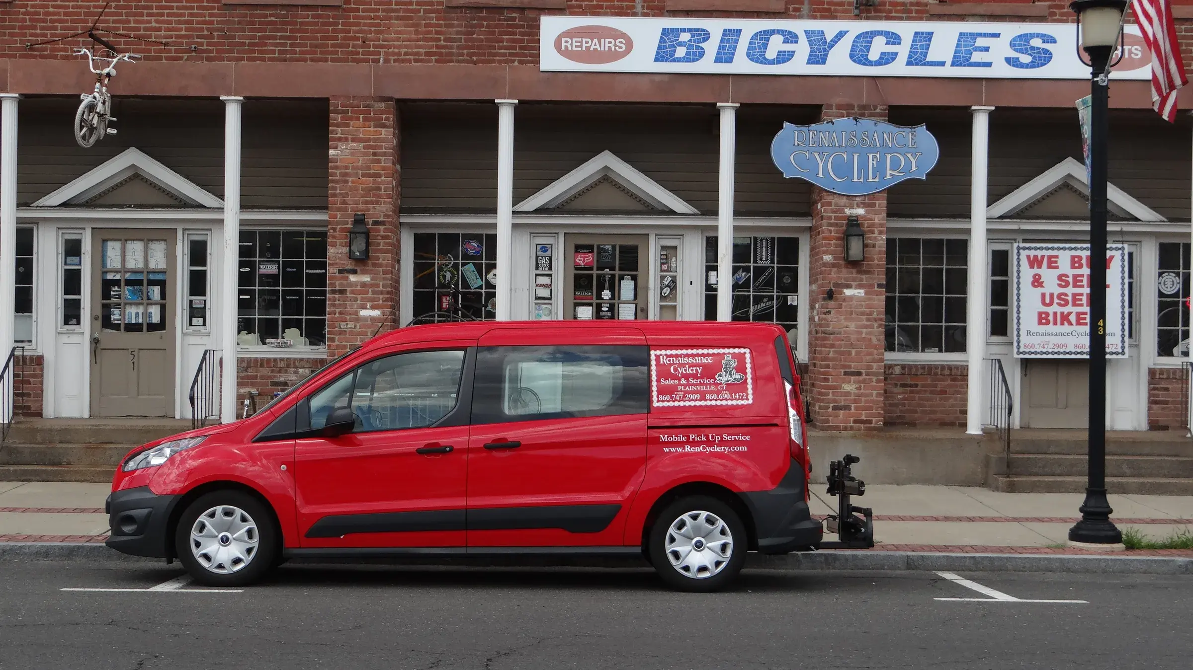The red Renaissance Cyclery pick-up van parked in front of the shop on West Main Street