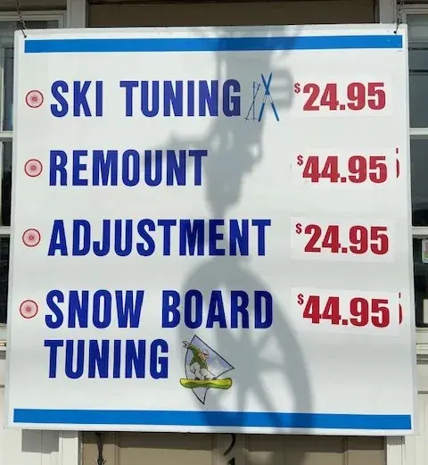 Renaissance Cyclery's printed ski and snowboard tuning price sign: ski tuning $24.95, remount $44.95, adjustment $24.95, snowboard tuning $44.95