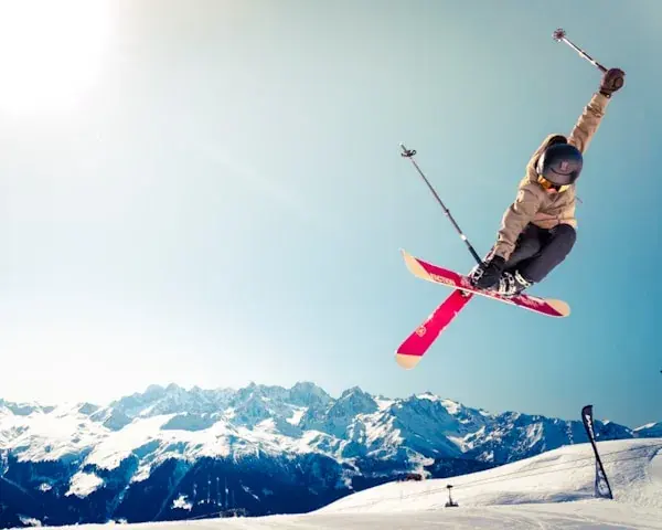 A skier mid-air over a mountain ridge